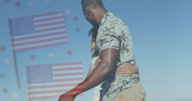 Amerikan bayrağı ve yıldızlarıyla kucaklaşan çift, açık mavi gökyüzüne karşı duruyor. Vatanseverlik, özgürlük, aşk, ilişki, kutlama, bağımsızlık