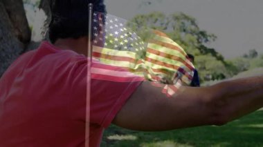 Parkta oynuyorlar, baba-kız Amerikan bayrağının animasyonuyla. Aile, bağ, oyun zamanı, açık hava, vatanseverlik, eğlence