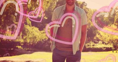 Açık havada, arka planda pembe kalp animasyonuyla gülümseyen bir adam. Mutluluk, neşe, ifade, ifade