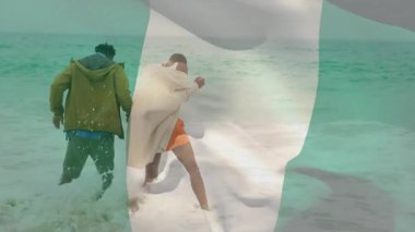 Okyanus dalgalarında yürüyen, arka planda bayrak animasyonu olan bir çift. Plaj, tatil, tatil, romantik, birliktelik, vatanseverlik