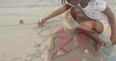 Çocuk kumsalda meditasyon yaparken kuma kalp çiziyor. Meditasyon, rahatlama, yaratıcılık, deniz kenarı, maneviyat, farkındalık