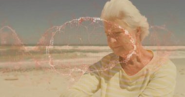 Kumsaldaki yaşlı kadın dijital ağ animasyonuyla onu örtüyor. Teknoloji, bağlantı, gelecek, yenilik, iletişim, kıdemli