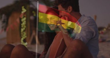 Sahilde, Gana bayrağı animasyon sahnesiyle kucaklaşan çift. Romantik, vatanseverlik, seyahat, tatil, ilişki, çeşitlilik