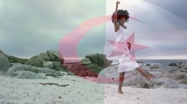 Kayalık plajda, beyaz elbiseli kadın şeffaf bayrak animasyonu kaplamalı. Kıyı şeridi, moda, kadınlık, özgürlük, sükunet, doğa