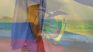 Sahilde yürümek, Ekvador bayrağını animasyon örtüsüyle tutan kişi. Seyahat, turizm, vatanseverlik, kıyı şeridi, kutlama, kültür