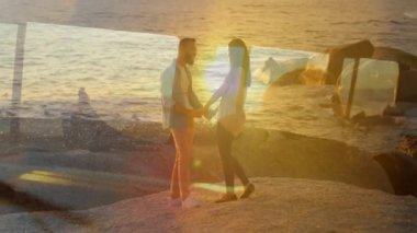 Kumsalda el ele tutuşmak, çift okyanus dalgaları animasyonuyla günbatımını izlemek. Romantizm, aşk, birliktelik, tatil, sükunet, rahatlama