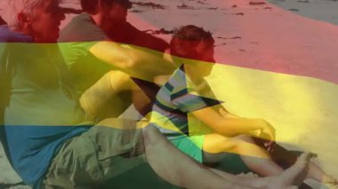 Sahilde oturan, arka planda Gana bayrağı animasyonu olan üç kişi. Tatil, tatil, seyahat, turizm, rahatlama, vatanseverlik