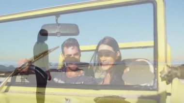 Üstü açık sarı bir arabada selfie çeken, arka planda sörf tahtası silueti olan bir çift. Seyahat, macera, yolculuk, tatil, yaşam tarzı, boş zaman