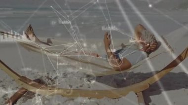 Hamakta dinlenen, plajda dijital ağ animasyonu yapan adam. Rahatlama, teknoloji, bağlantı, tatil, sükunet
