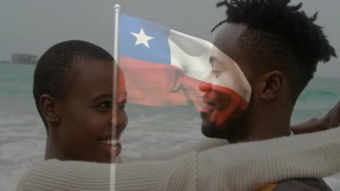 Şili bayrağıyla kucaklayan çift animasyonda neşeli ifadeler sergiliyor. Aşk, vatanseverlik, Güney Amerika, kutlama, mutluluk, çeşitlilik