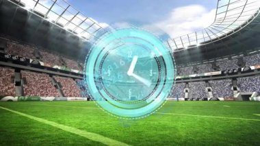 Futbol stadyumunda dijital saat animasyonu, yeşil alan ve tezahürat yapan kalabalık. Spor, rekabet, seyirci, coşku, heyecan, zamanlayıcı