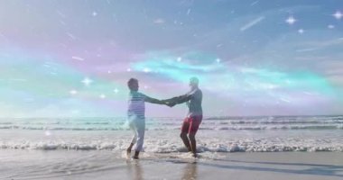 Okyanus dalgaları üzerinde ışıl ışıl ışık animasyonları olan kumsaldan hoşlanan çift. Tatil, romantizm, yaz, gün batımı, seyahat, tropik