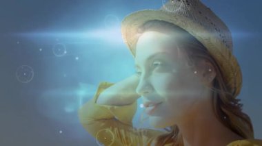 Hasır şapka takan, dışarıda dijital animasyonu olan güneş ışığı alan bir kadın. Doğa, teknoloji, moda, yenilik, sanatsal, güneşli