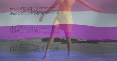 Neşeli bir şekilde dans eden, renkli çizgili ve animasyon metinleriyle sahilde dans eden bir kadın. Tropik, tatil, tasasız