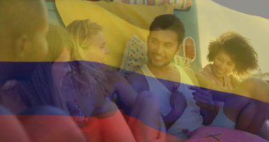 Plajda dinlenen, Kolombiya bayrağı animasyonu olan bir grup arkadaş. Seyahat, tatil, arkadaşlık, eğlence, kutlama, kültür