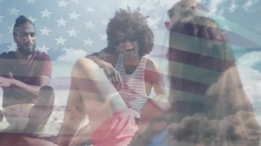 Kumsalda, arkadaşlar bulutlu gökyüzünde Amerikan bayrağı animasyonuyla gülüyorlardı. Tatil, özgürlük, kutlama, sahil, dostluk, yaz