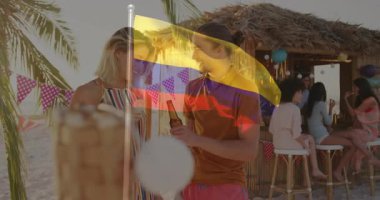 Plaj partisinde, Kolombiya bayrağı animasyon örtüsüyle içki içen iki kişi. Kutlama, içecek, açık hava, sosyalleşme, Brezilya, eğlence