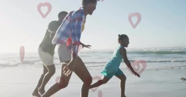 Sahilde koşmak, neşeli sahnelerle dolu kalp animasyonlu bir aile. Tatil, mutluluk, sağlık, açık hava, birliktelik.