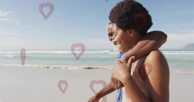 Yaşlı bir adam ve genç bir kadın plajda kalp animasyonuyla yürüyor. Aile, kaynaşma, açık hava, tatil, rahatlama, boş zaman