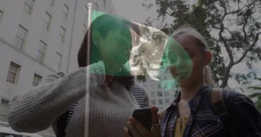 Telefona gülümseyen, Nijerya bayrağı taşıyan iki kişi şehir ortamında yatıyordu. İletişim, kentsel yaşam, bağlantı, vatanseverlik, teknoloji, kutlama