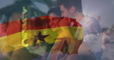 Sahilde kucaklaşan, arka planda Gana bayrağı animasyonu olan çift. Romantizm, birlik, kutlama, aşk, seyahat, vatanseverlik