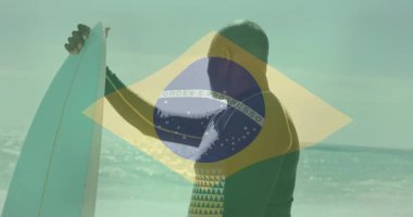 Brezilya bayraklı sörf tahtası, sahilde hareketli sörfçü. Sörf, spor, tropik, okyanus, yaz, macera