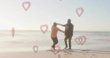 Sahilde dans etmek, arka planda kalp animasyonlarıyla eğlenen bir çift. Aşk, dans, aşk, kutlama, yaz