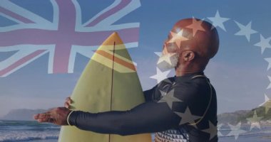 Arka planda İngiltere ve AB bayraklı sörf tahtası, ayakta duran adam. Sörf, çok kültürlü, vatanseverlik, okyanus, yaz, eğlence