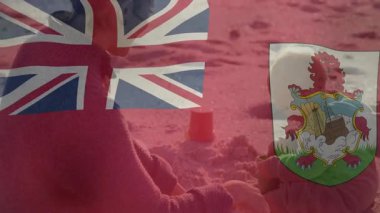 Çocuk kumlu sahilde Bermuda bayrağı ve armalı animasyon ile oynuyor. Tatil, yaz, oyun zamanı, tatil, vatanseverlik, okyanus