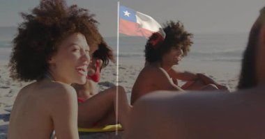 Şili bayrağı sallıyor, arkadaşlar sahilde dinleniyor dalgaların animasyonunun tadını çıkarıyorlar. tatil, rahatlama, arkadaşlık, kutlama