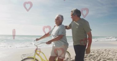 Sahilde bisikletle yürüyen yaşlı bir çift, kalp animasyonları üst üste biniyor. Son sınıf, romantizm, bisiklet, aşk, tatil, dinlenme