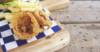 Marullu hamburger, domates, patates kızartması ve kareli kağıtta soğan halkaları. Fast food, yemek, öğle yemeği, yemek, mutfak, lezzetli