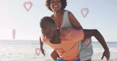 Sahilde, bir çift kalp şekillerinin animasyonuyla sırtına biniyor. Aşk, eğlence, birliktelik, aşk, mutluluk, yaz