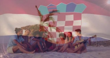 Sahilde oturan, Hırvat bayrağı animasyonuyla örtüşen bir grup arkadaş. Arkadaşlık, tatil, yaz, sahil şeridi, kutlama, doğa