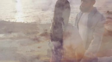 Günbatımını dingin okyanusun üzerinde geçirerek romantik animasyon arkaplanı oluşturan çift. Romantizm, kucak, sükunet, aşk, sahil şeridi