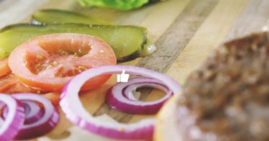 Dilimlenmiş soğan ve domateslerin üzerine doğranmış simgelerle hamburger malzemelerinin animasyonu. Fast food, illüstrasyon, aşçılık, taze