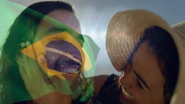 Elinde Brezilya bayrağı, arka planda güneş ışığıyla gülümseyen kadınlar. Vatanseverlik, kutlama, ulusal gurur, neşe, yaz, birlik