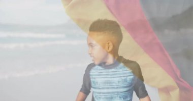 Sahilde, arka planda Alman bayrağı olan bir çocuk vardı. Yaz, tatil, vatanseverlik, kutlama, eğlence, eğlence.