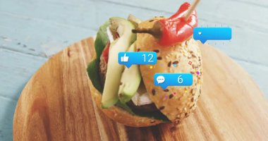 Tahtaya yerleştirilmiş hamburgerler sosyal medya bildirimleri ile örtüşüyor. Fast food, aşçılık, gastronomi, dijital, teknoloji, konsept