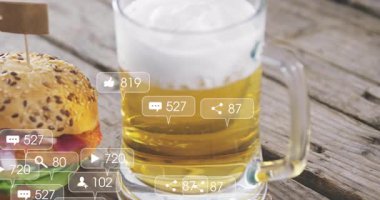 Hamburger ve bira, sosyal medya bilgilendirme ikonlarının animasyonuyla birlikte masada. Fast food, içecek, içecek, içecek, gurme, yemek, dijital