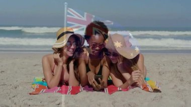 Güneş şapkası takıyor, plajda Avustralya bayrağı animasyon örtüsü olan üç kadın. Yaz, arkadaşlar, tatil, seyahat, güneş şapkası, boş zaman