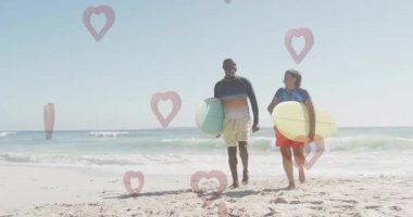Baba ve oğul plajda kalp şekilleriyle yürüyorlar. Aile, bağ, babalık, ebeveynlik, birliktelik, mutluluk.