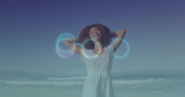 Kollarının üzerinde parlak daireler çizen sahilden hoşlanan bir kadın. dijital, teknoloji, rahatlatıcı, yaz