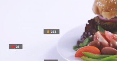 Bir tabak taze salata ve hamburger üzerine sosyal medya bilgilendirmeleri. Teknoloji, iletişim, fast food, sağlıklı beslenme, dijital, online