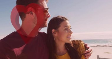 Sahilde romantik bir ortamda kalp animasyonuyla kucaklaşan bir çift. Aşk, ilişki, şefkat, şefkat