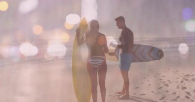 Sahilde sörfçüler Bokeh Light efektleriyle beşlik çakıyor. Sörf, arkadaşlık, kutlama, dalgalar, okyanus, takım çalışması