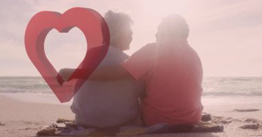 Sahilde oturan iki kişi, üzerinde kalp animasyonu olan. Aşk, aşk, deniz kenarı, çift, ilişki, tatil