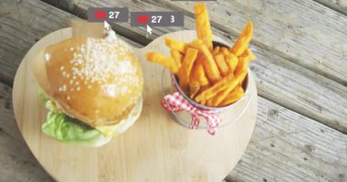 Tahta tahtada hamburger ve patates kızartması ve sosyal medya simgelerinin animasyonu. Fast food, patates kızartması, online, pazarlama, iletişim, dijital