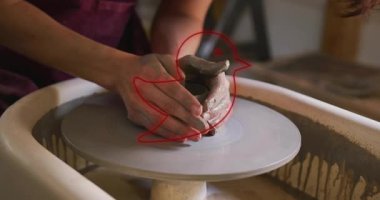 Çömlek çarkında kil şekillendirme, kırmızı kuş hatlarıyla animasyon yapan kişi. El sanatları, seramik, yaratıcılık, tasarım, el işi, zanaatkarlık