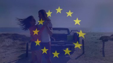 Plajda kamyonla kucaklaşan, Avrupa Birliği yıldız animasyonlu çift. Romantizm, seyahat, tatil, özgürlük, tatil, aşk